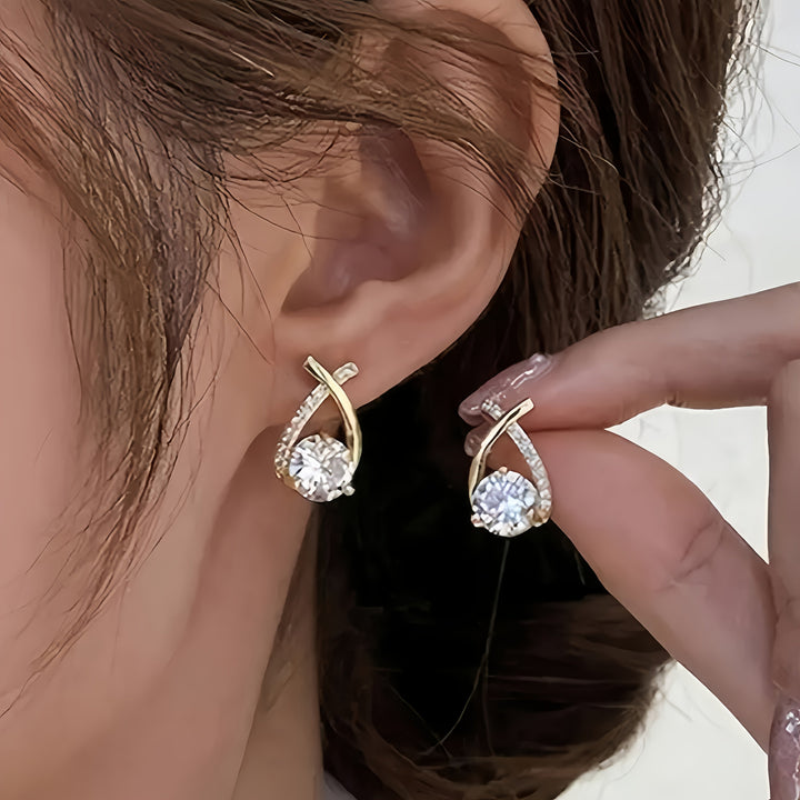 Boucles d'oreilles à clou avec croix dorée et zircons